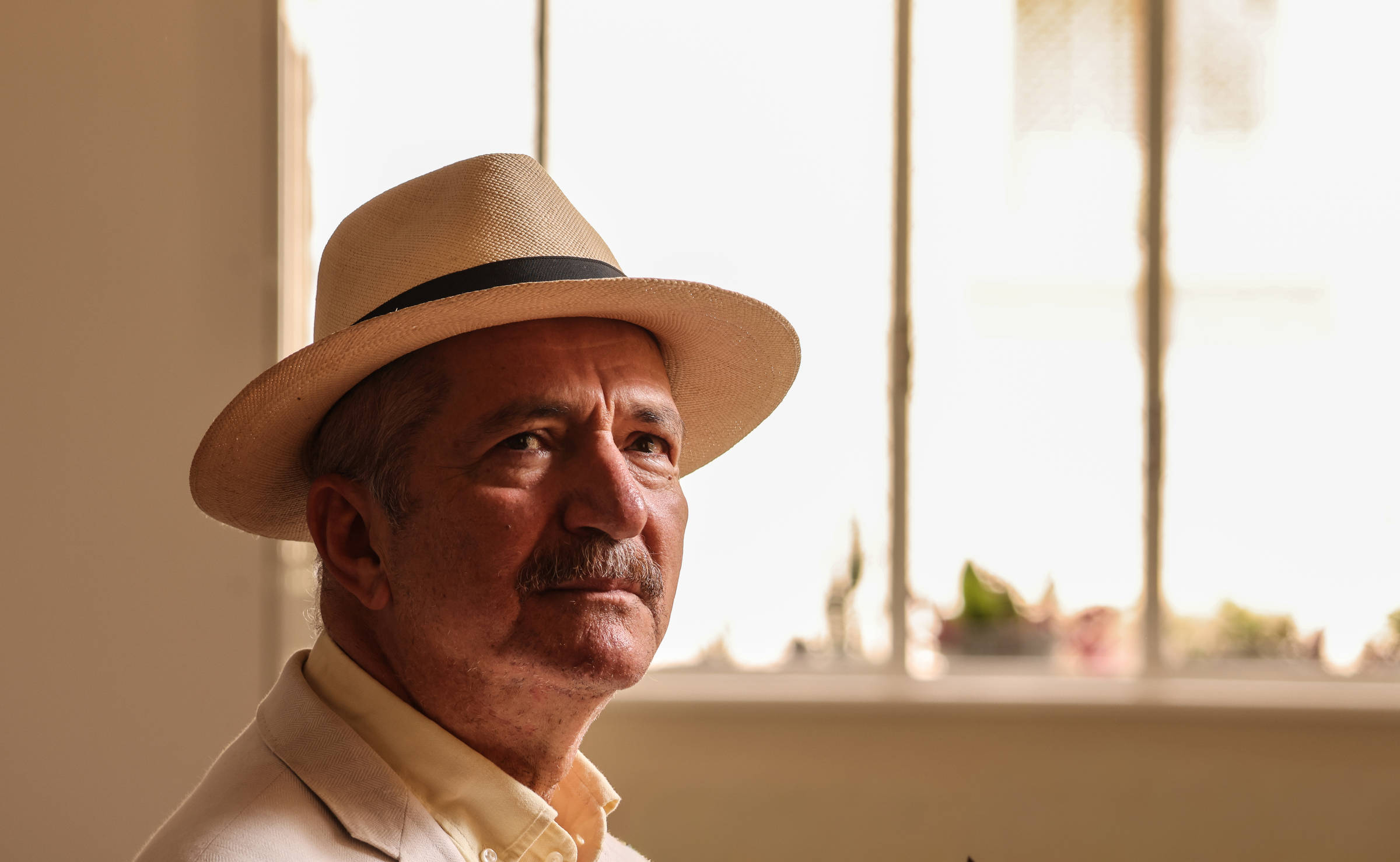 Aldo Rebelo de chapéu claro e camisa bege em ambiente interno