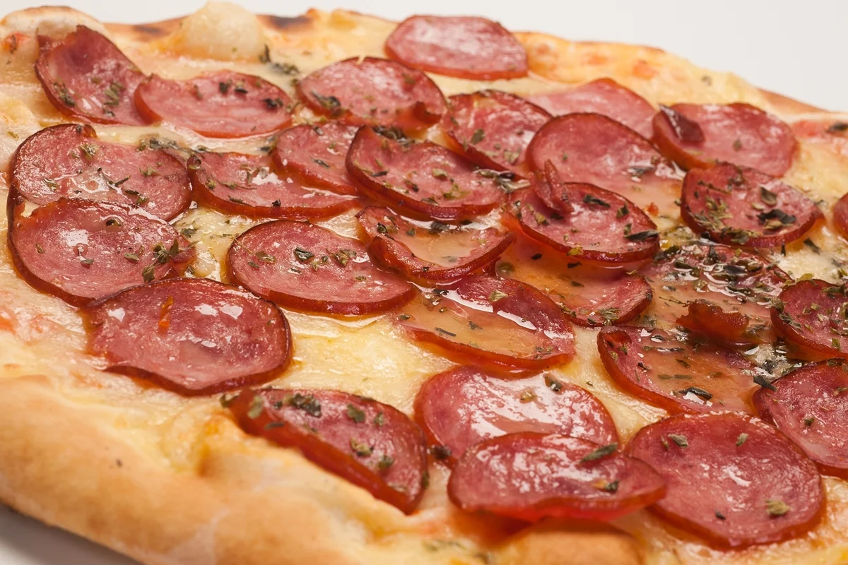 Pizzas sendo preparadas em bancada