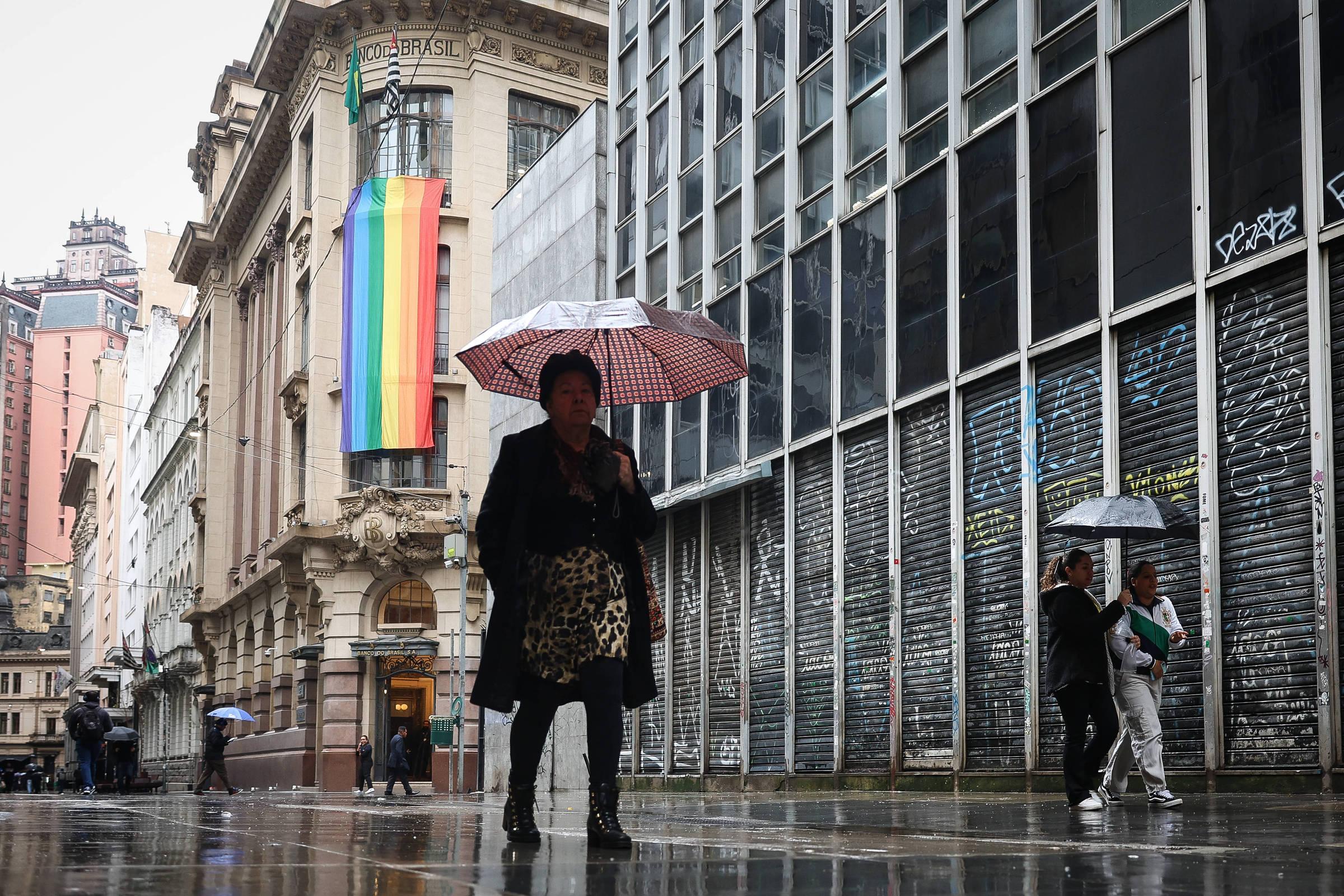 Pedestres se protegem da chuva e do frio no centro de São Paulo