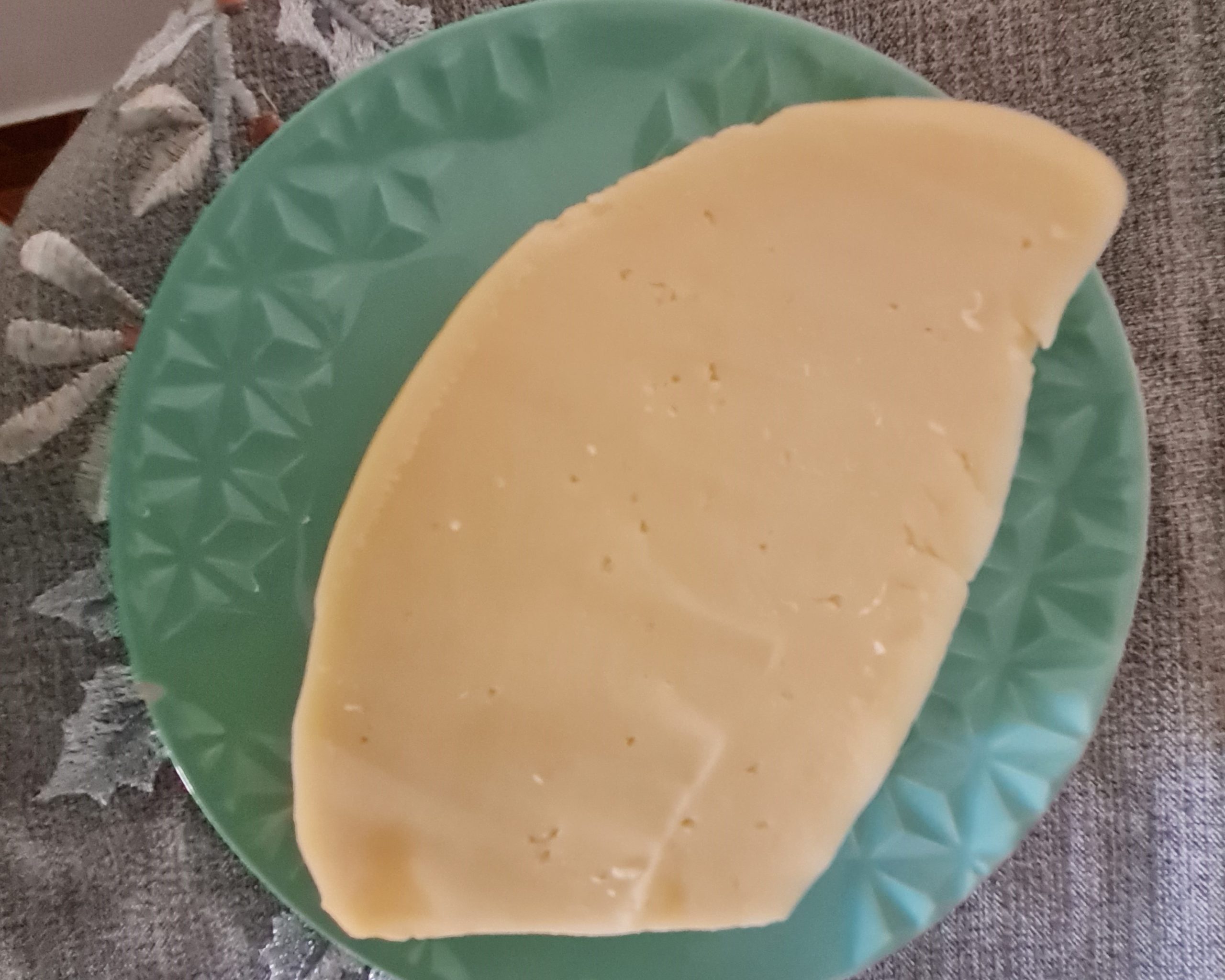 Queijo com furinhos sobre superfície clara