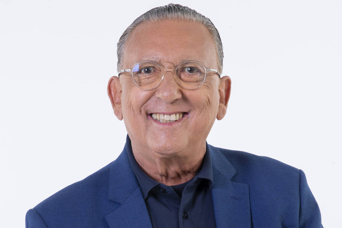 Galvão Bueno segurando uma bola de futebol
