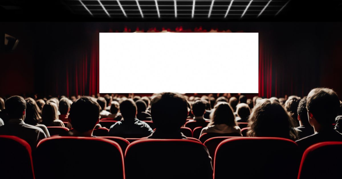 Sala de cinema cheia com público diante da tela