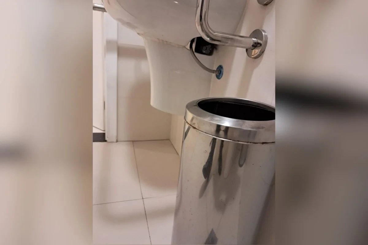 Homem em corredor de prédio comercial próximo a banheiro feminino