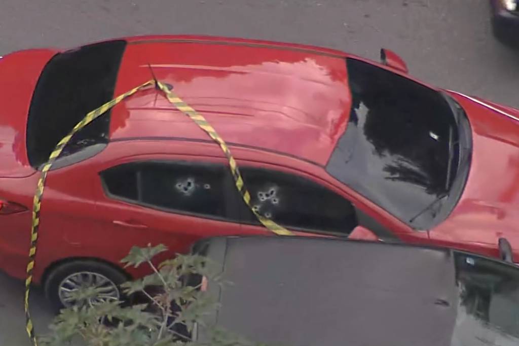 Carro vermelho com marcas de tiros em Cotia