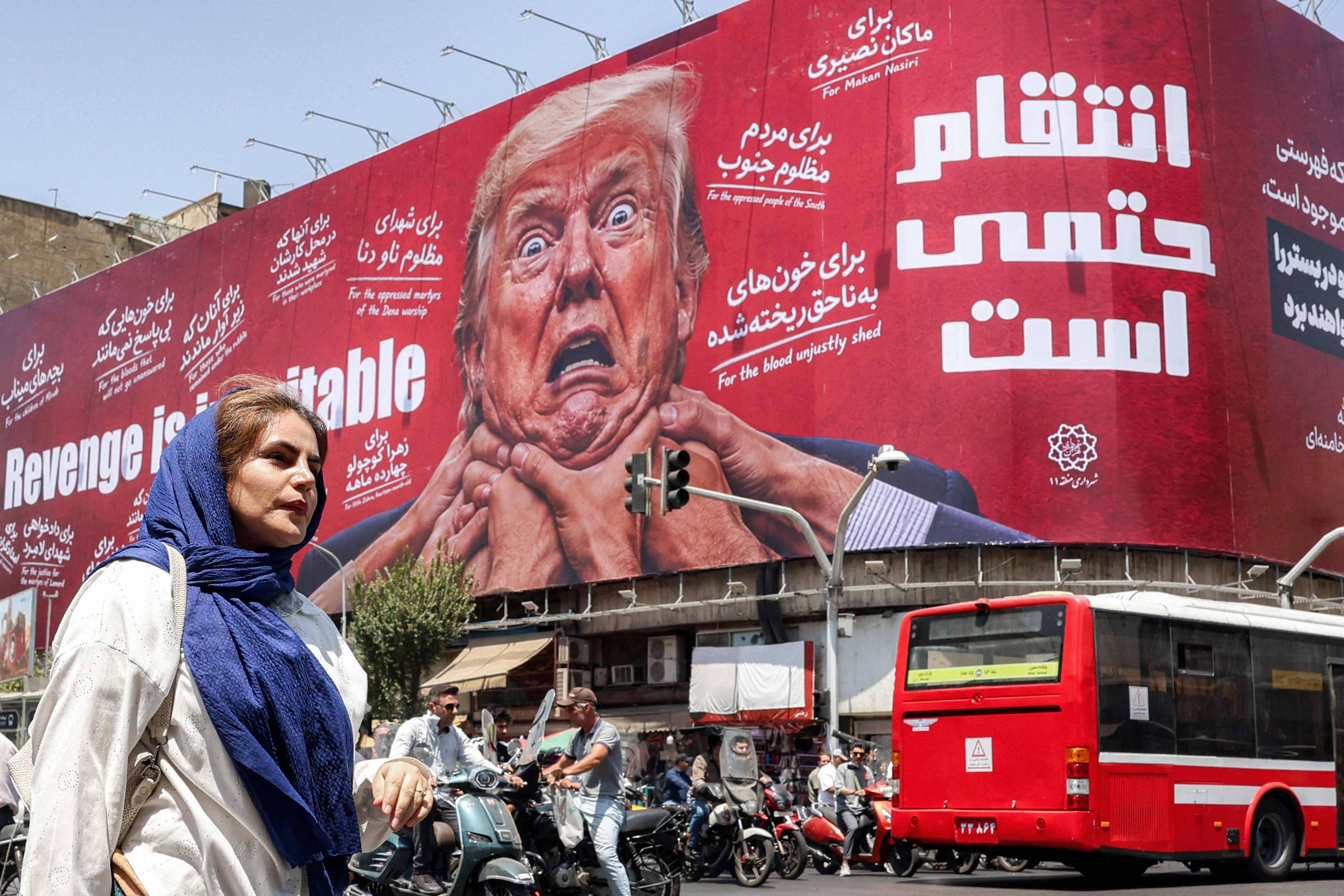 Moradora de Teerã caminha diante de outdoor contra Donald Trump