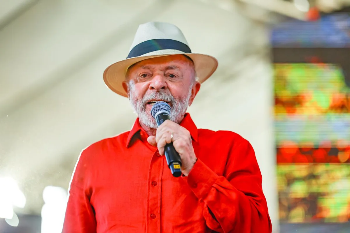 Lula com a mão sobre a bandeira do Brasil