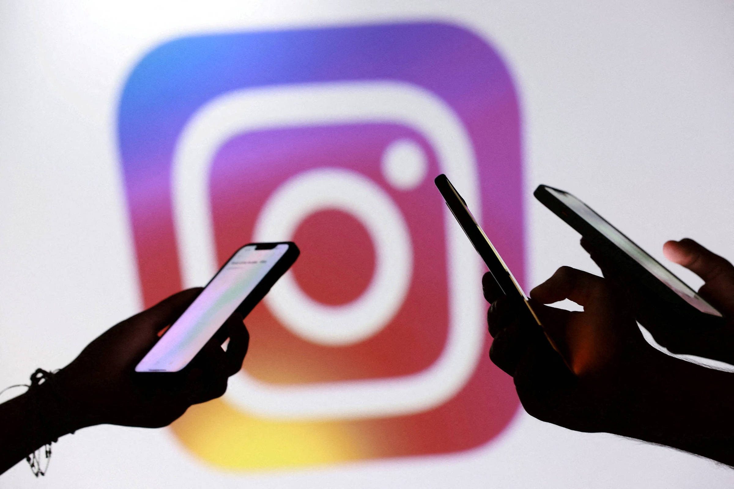 Celulares diante do logotipo do Instagram