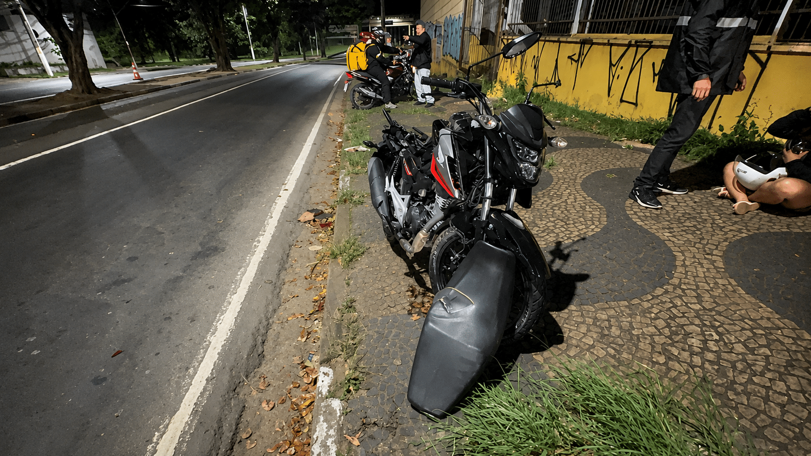 Motociclista caído em avenida de Campinas próximo a uma árvore