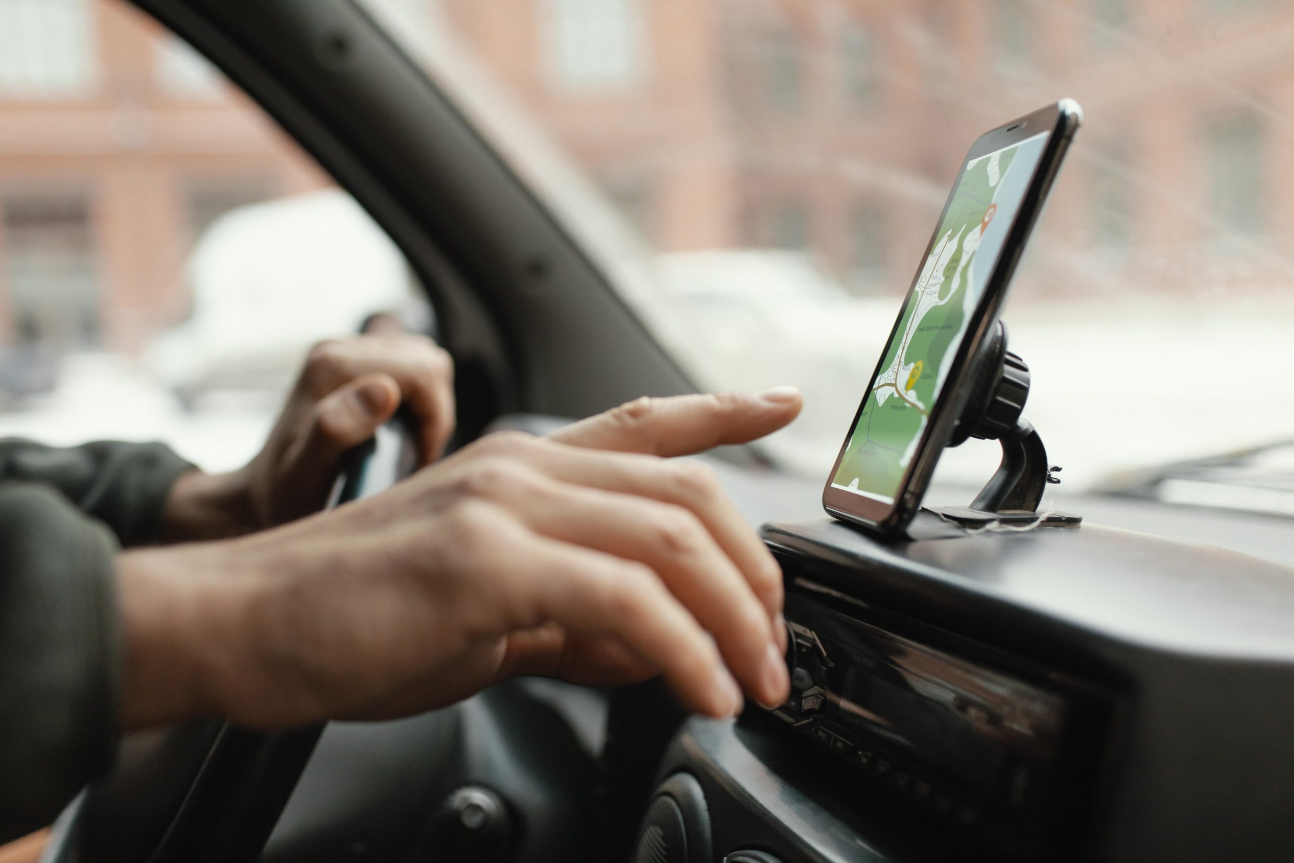 Motorista segurando celular dentro de um carro