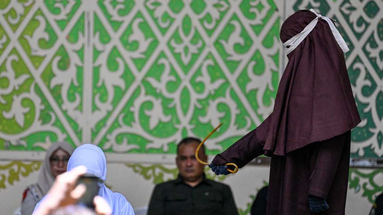 Mulher ajoelhada durante punição pública em Aceh, na Indonésia