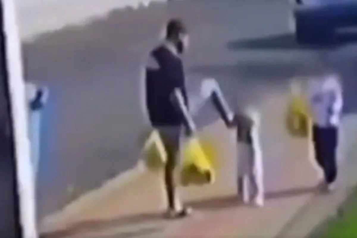 Homem ao lado de crianças em uma rua
