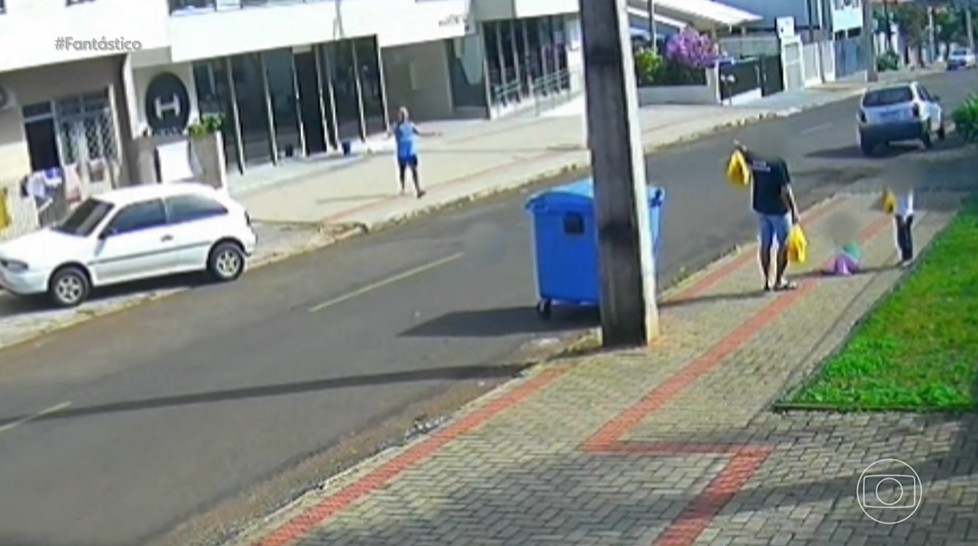 Homem caminhando com duas crianças em rua de Francisco Beltrão