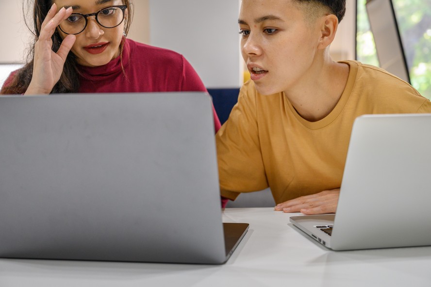 Estudantes em sala de aula com notebooks e cadernos