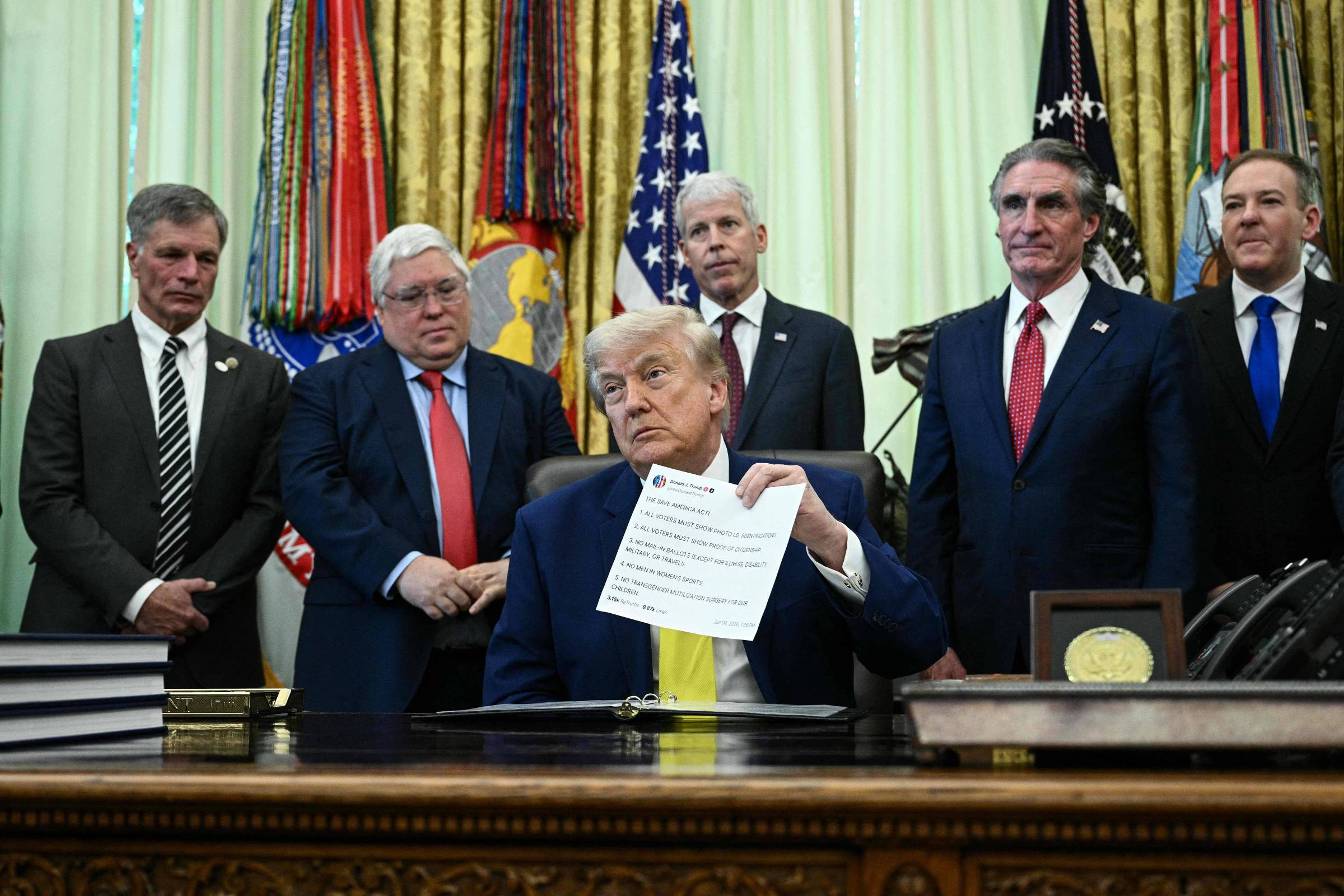 Donald Trump segura uma cópia impressa de publicação no Truth Social