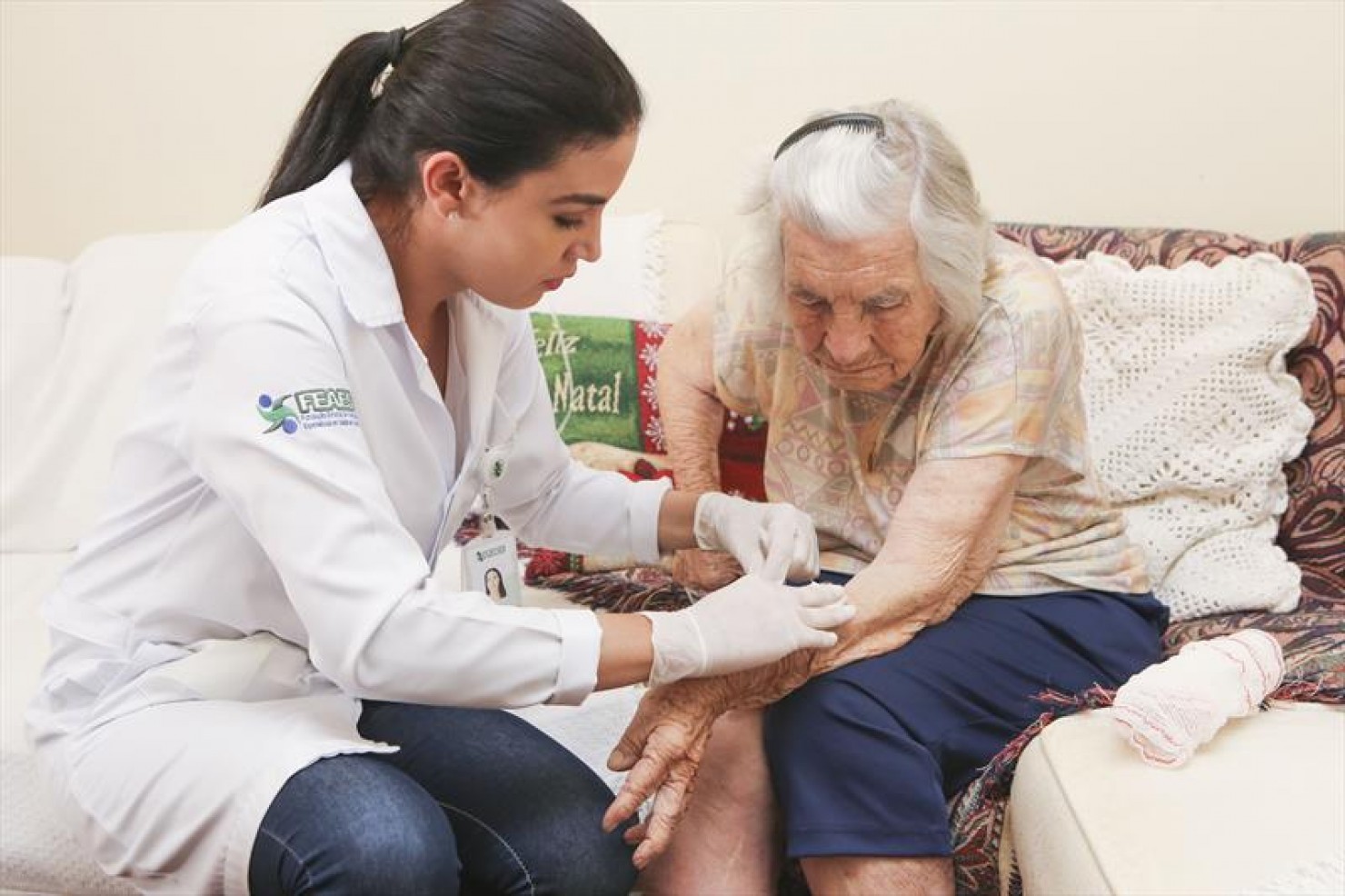 Profissional de saúde durante atendimento domiciliar a idoso
