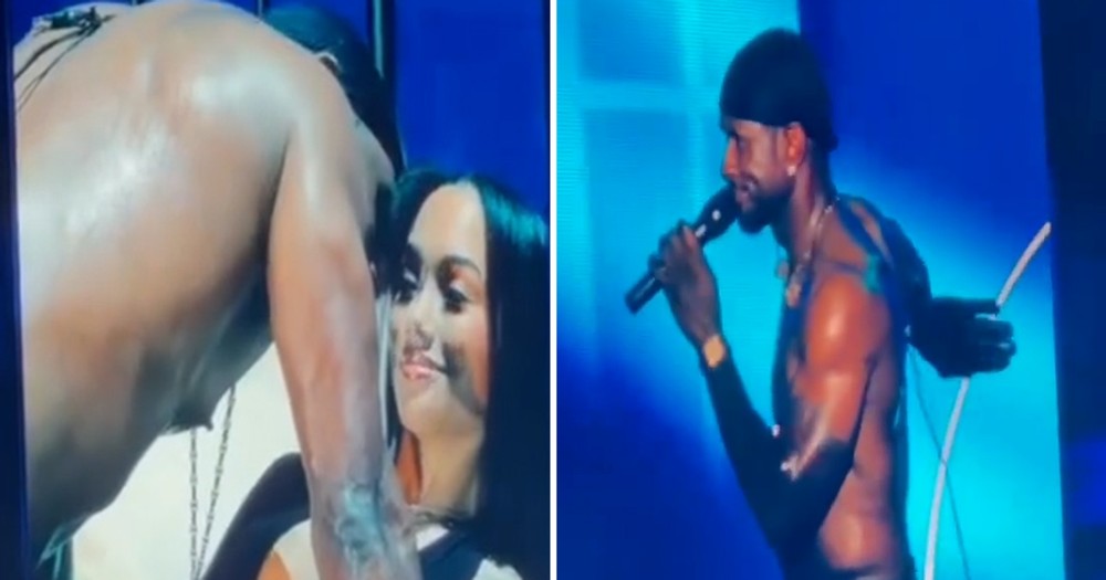 Usher durante apresentação ao lado de fã no palco