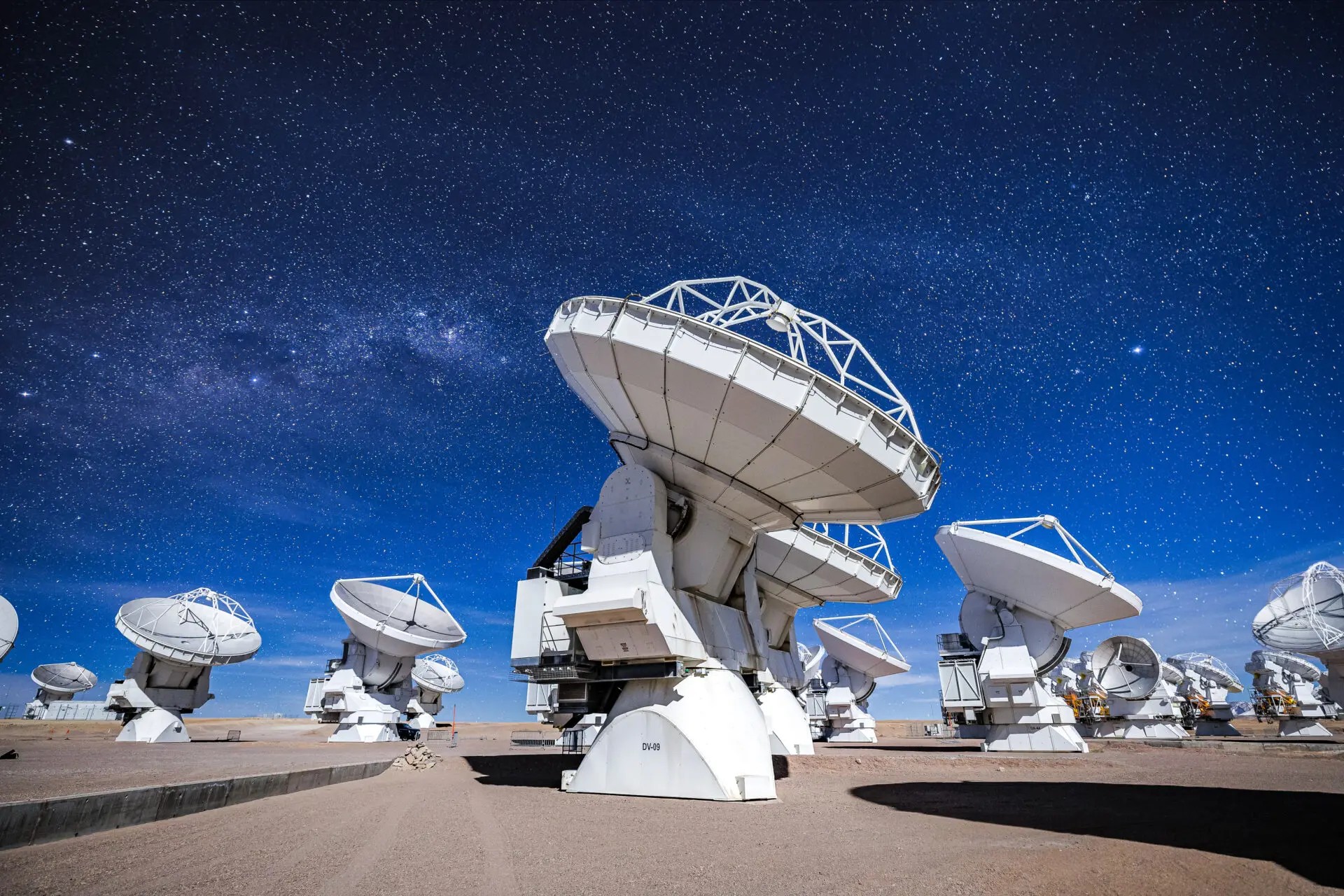 Antenas do observatório ALMA apontadas para o céu durante noite iluminada pela Lua no Chile