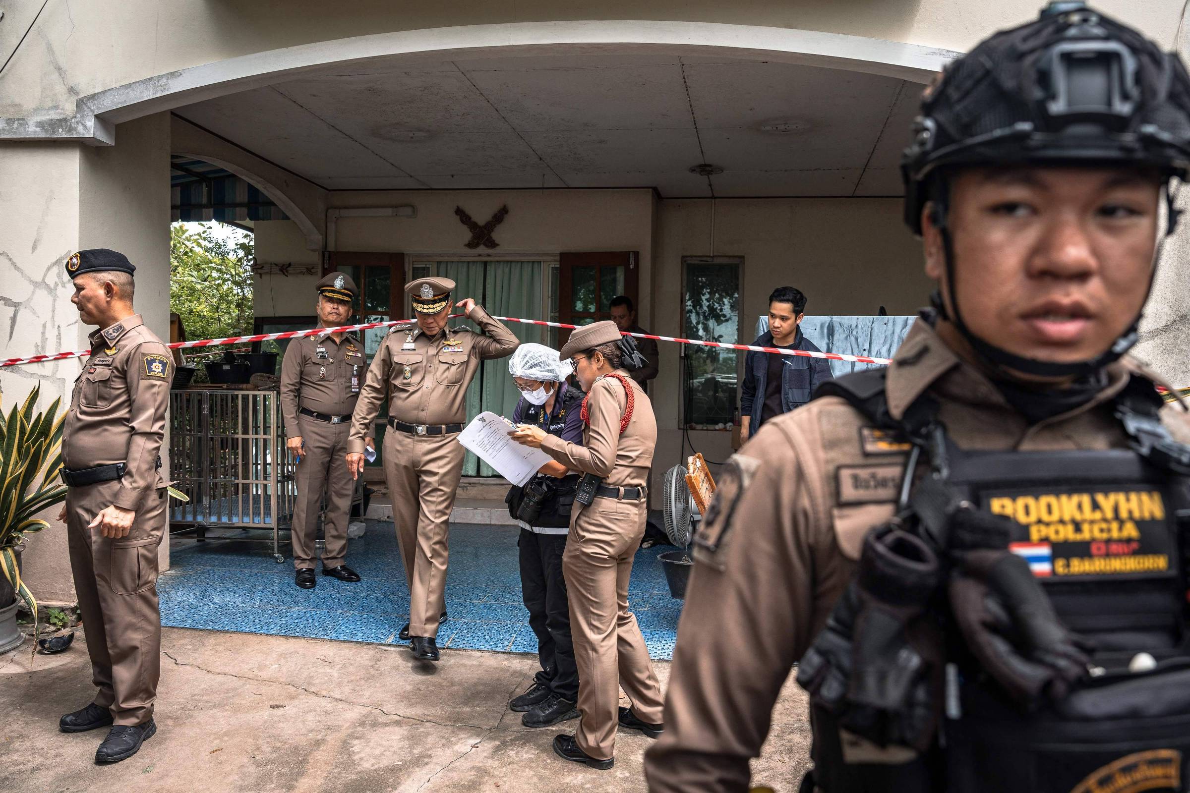 Policiais em frente à residência onde adolescente matou os avós em Nonthaburi