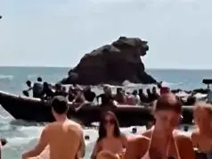 Lancha próxima à areia durante chegada de imigrantes à praia de Cala del Barco