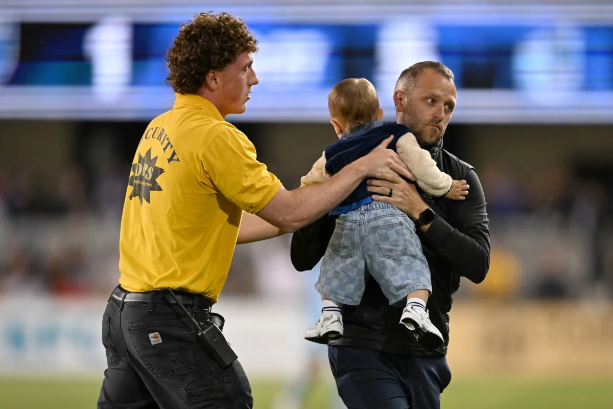 Bebê no gramado durante partida de futebol