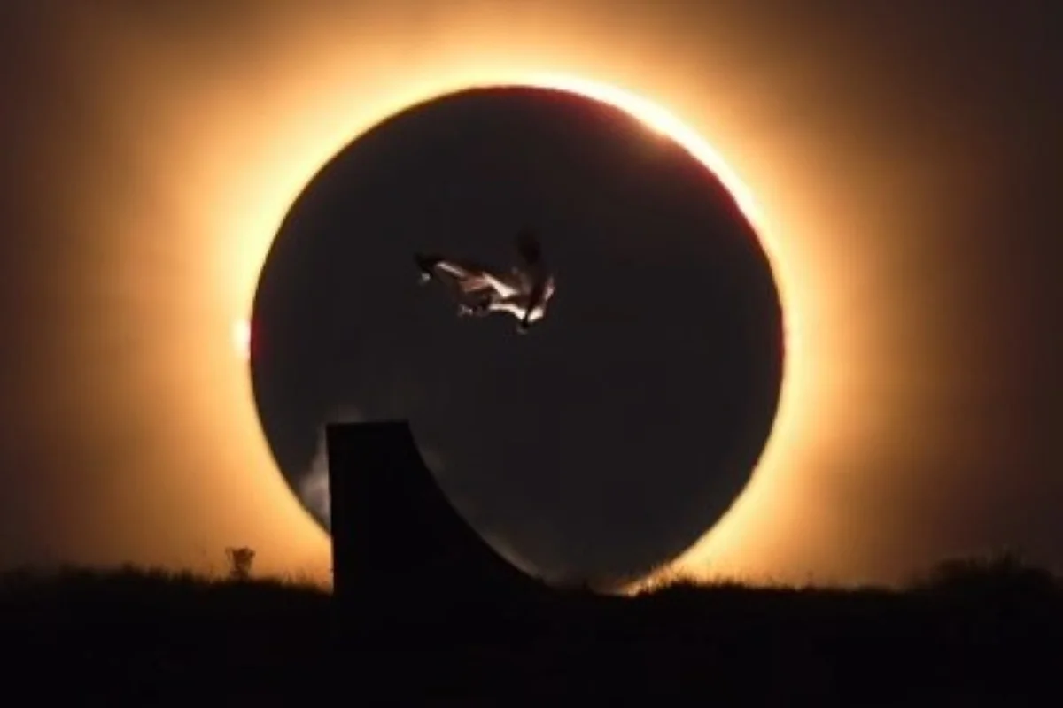 Danny León executa manobra de skate diante de eclipse solar