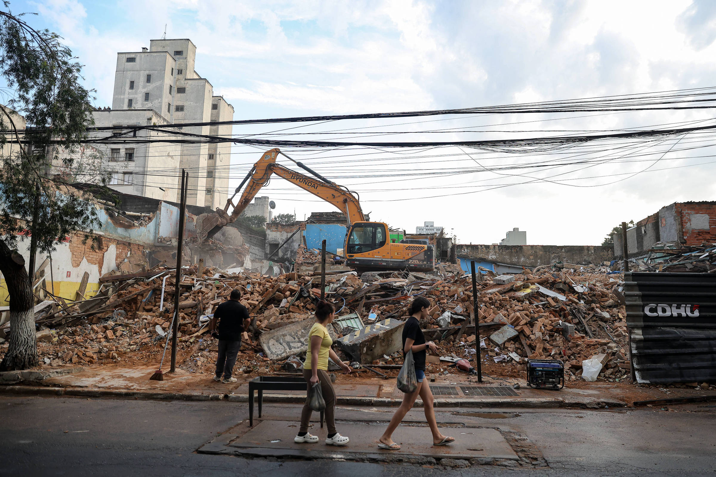 Escavadeira remove entulho em terreno nos Campos Elíseos, com o edifício Henrique ao fundo
