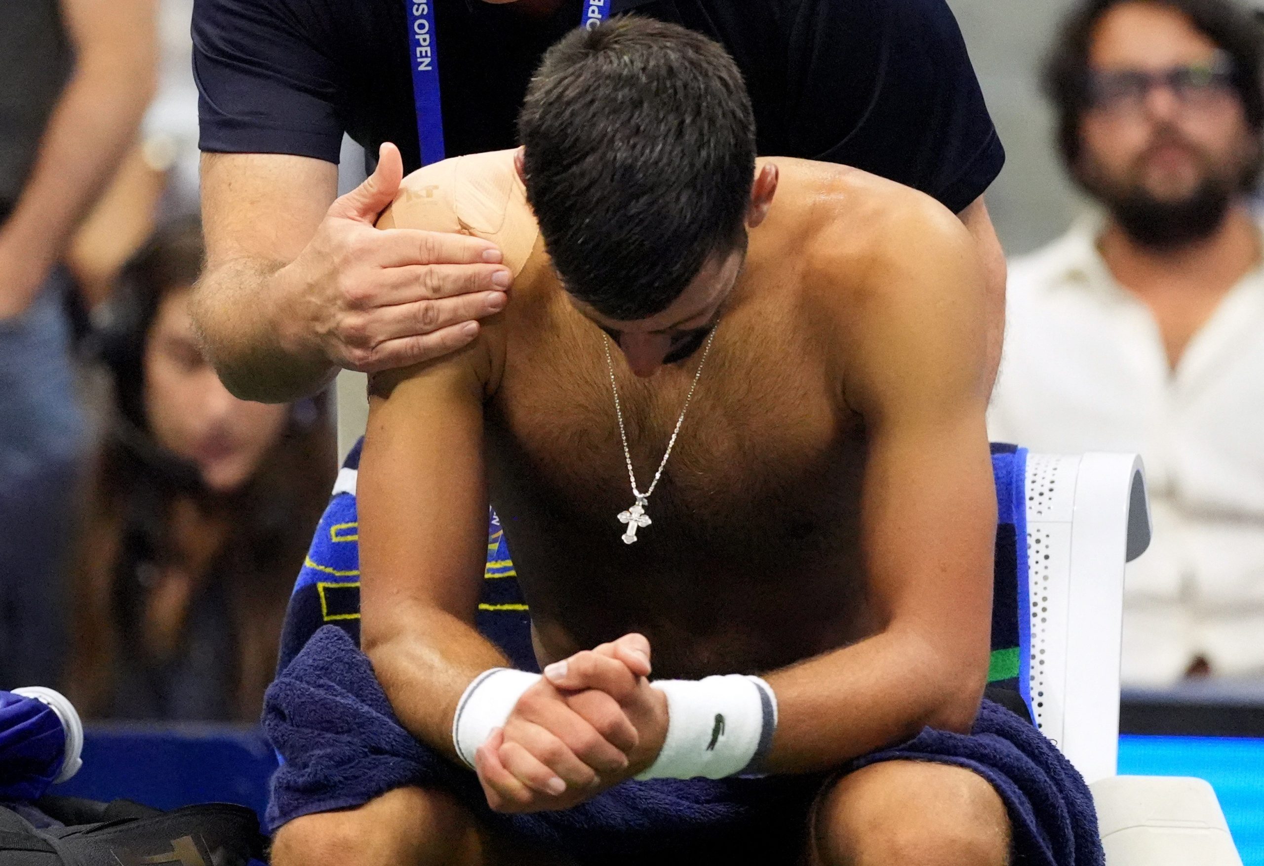 Novak Djokovic sentado na cadeira durante partida do US Open