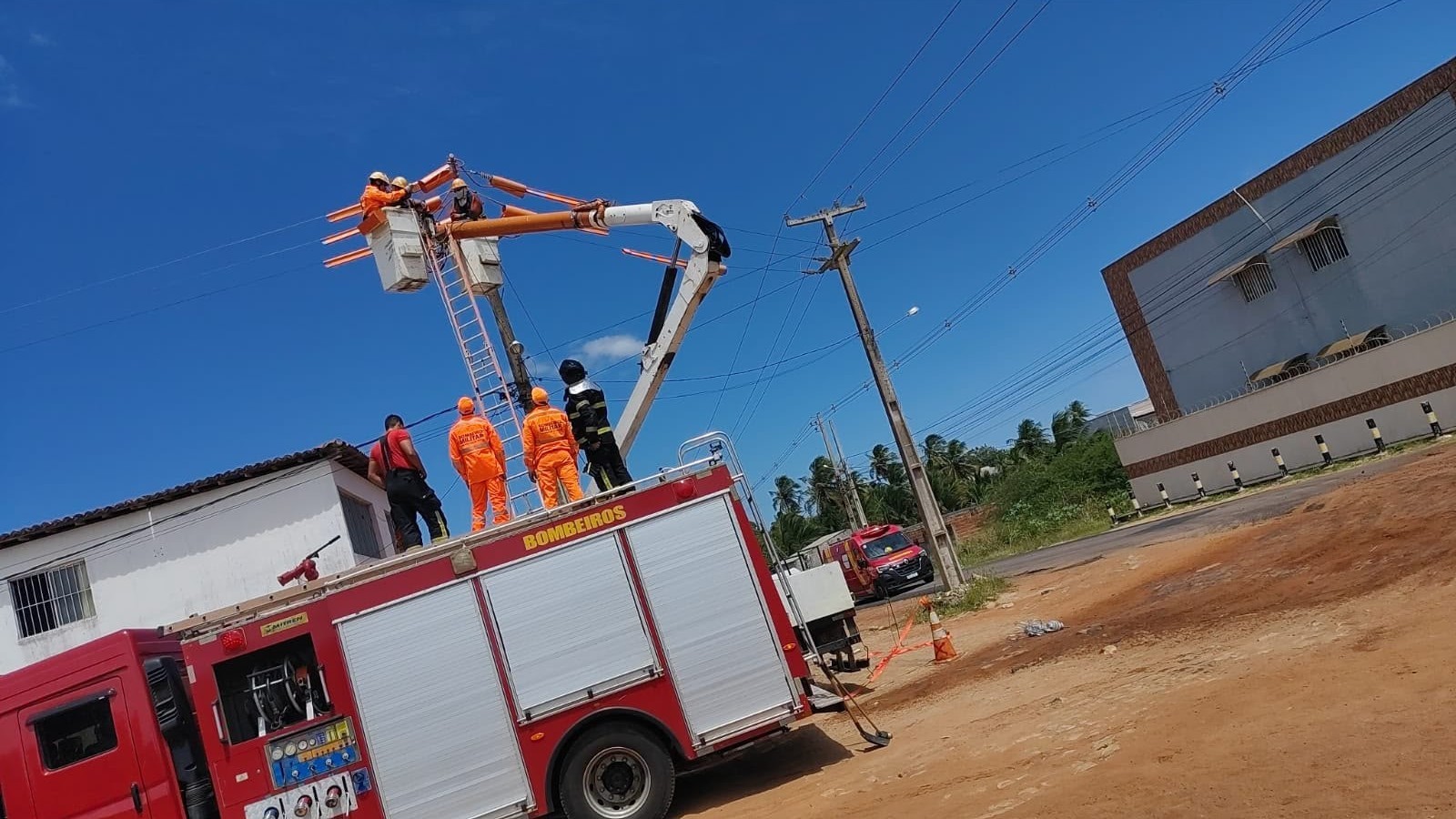 Trabalhadores no cesto de caminhão-guindaste durante resgate em João Câmara