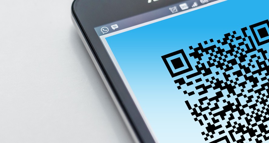 Pessoa usa celular para escanear um QR Code