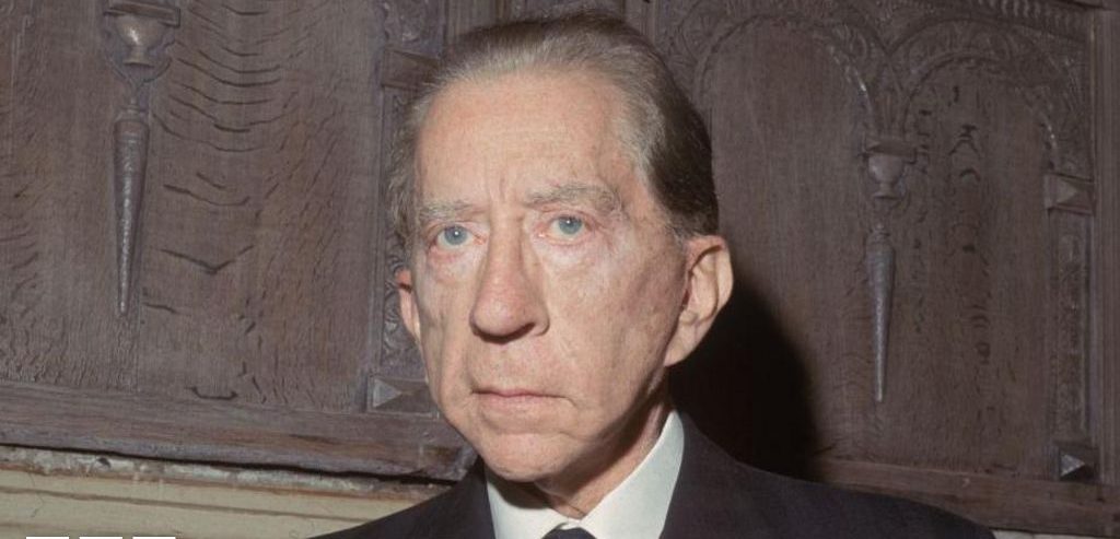 J. Paul Getty sentado à mesa com um cachorro