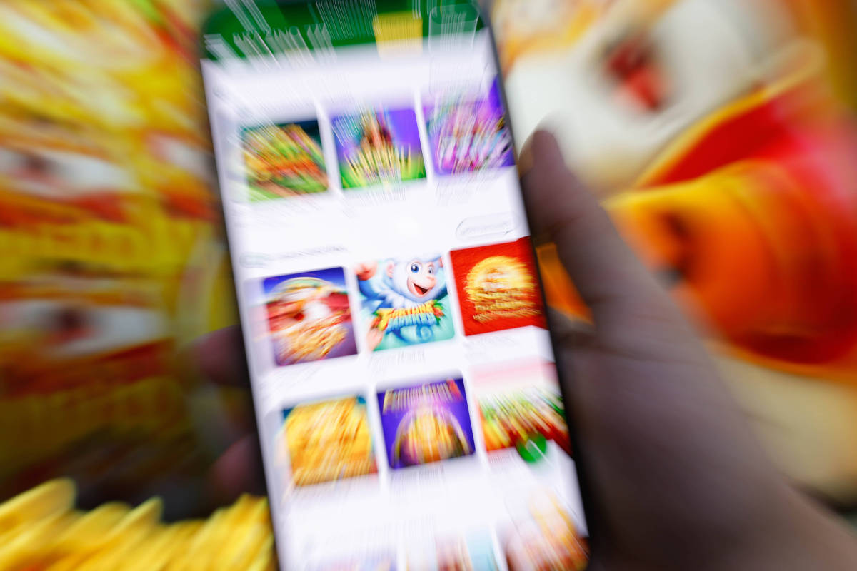 Pessoa segura celular com tela de jogos digitais
