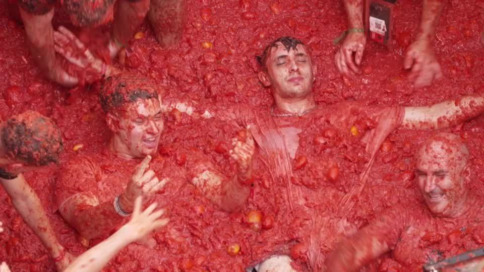 Participantes cobertos de tomate durante a La Tomatina em Buñol