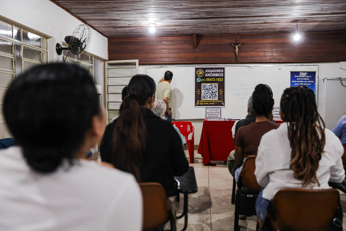 Participantes sentados durante reunião dos Jogadores Anônimos em São Paulo