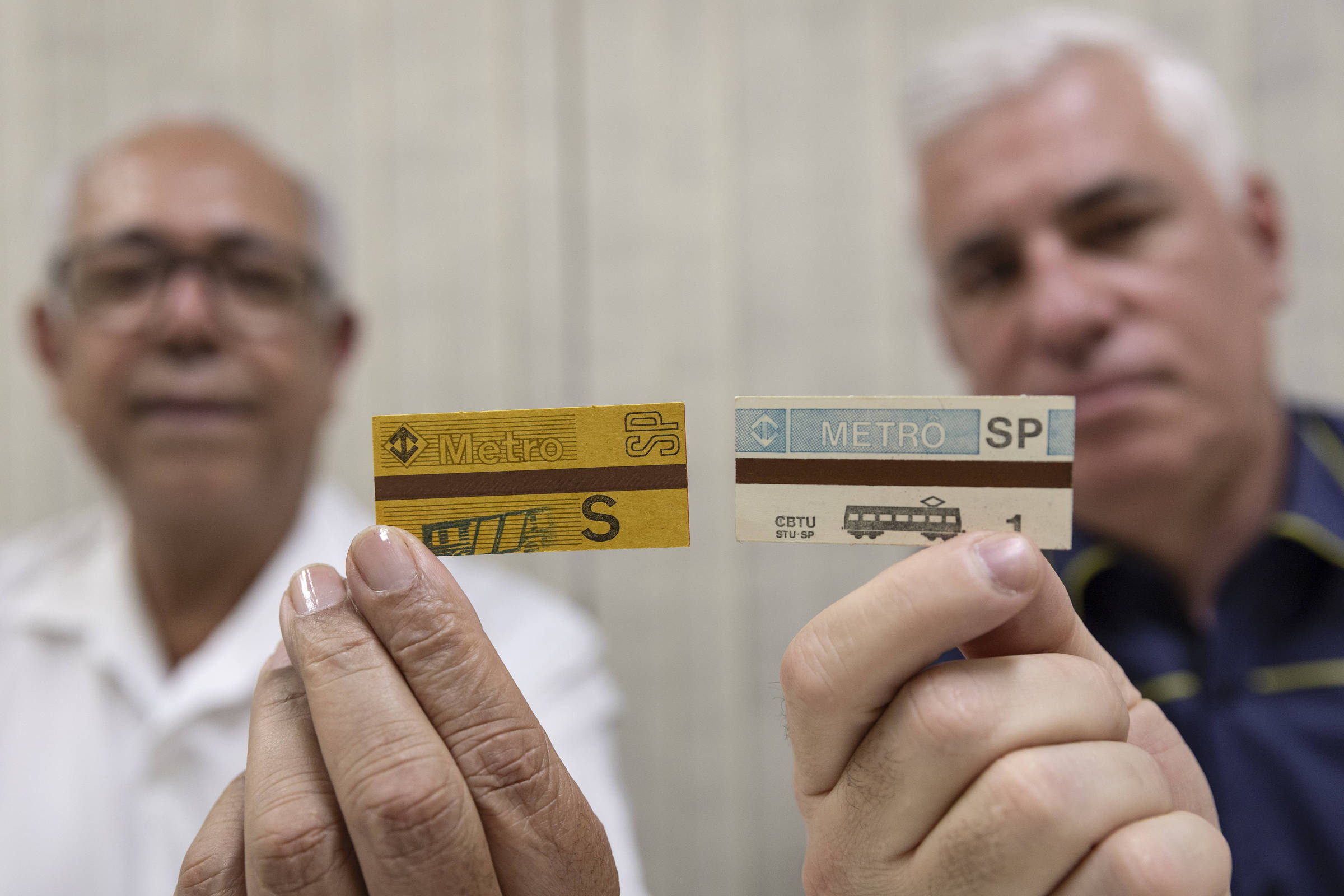 Funcionários do Metrô de São Paulo seguram bilhetes magnéticos antigos