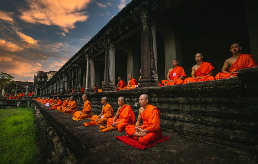 Monges budistas com roupas laranja durante meditação