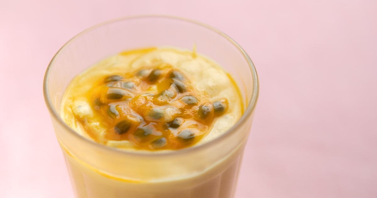 Mousse de maracujá cremosa decorada com polpa e sementes da fruta