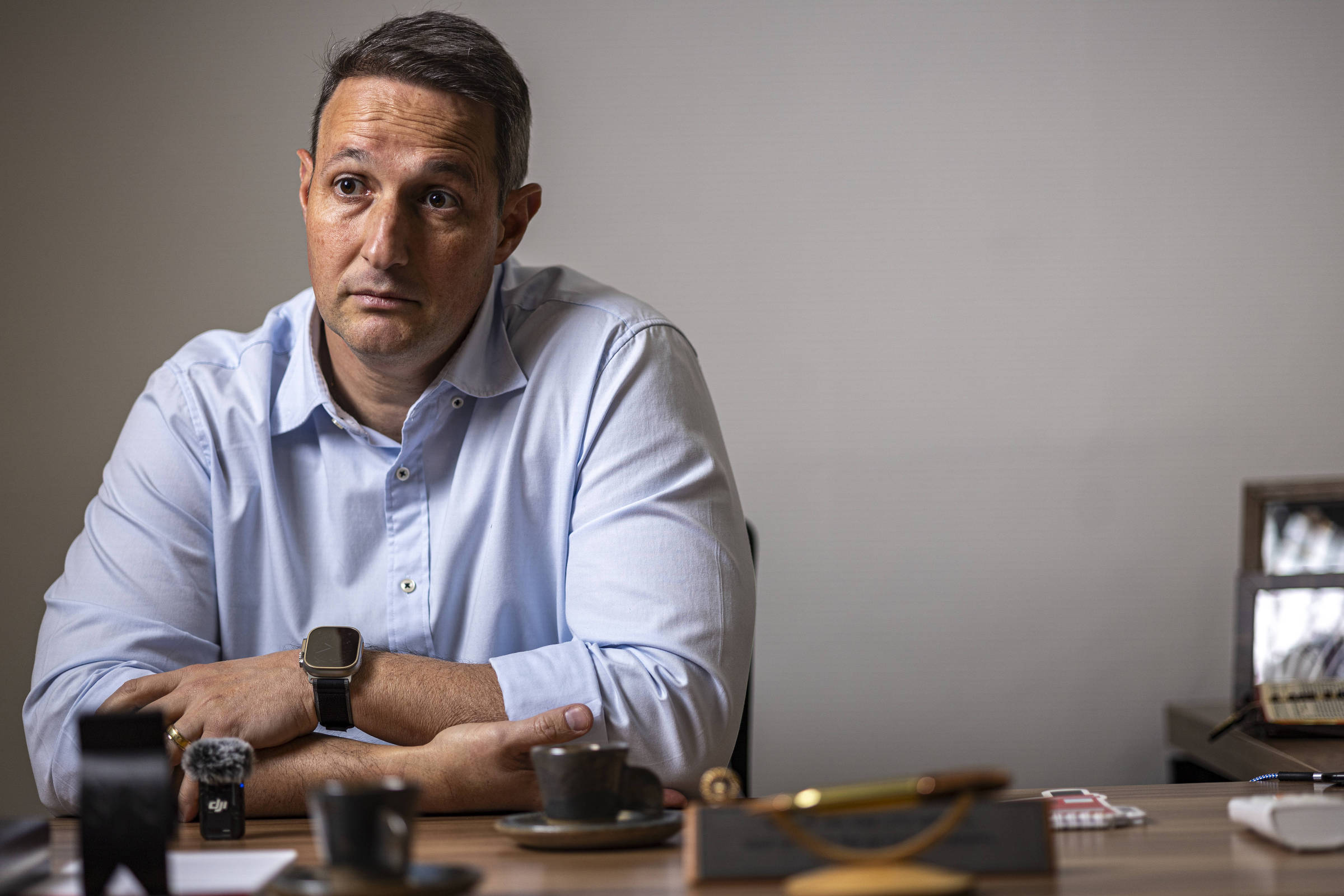 Guilherme Derrite sentado à mesa