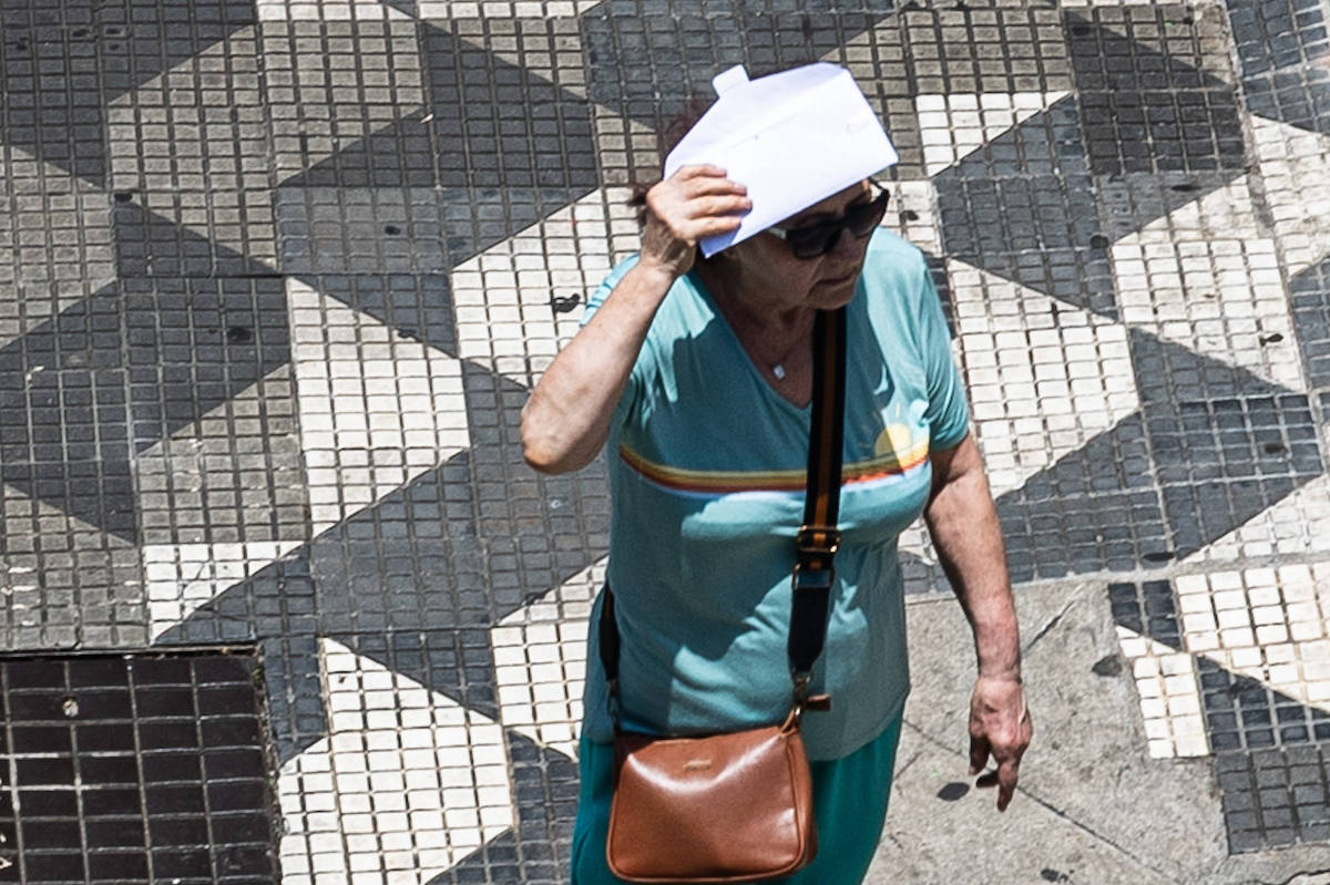 Mulher se protege do sol no Viaduto do Chá, no centro de São Paulo