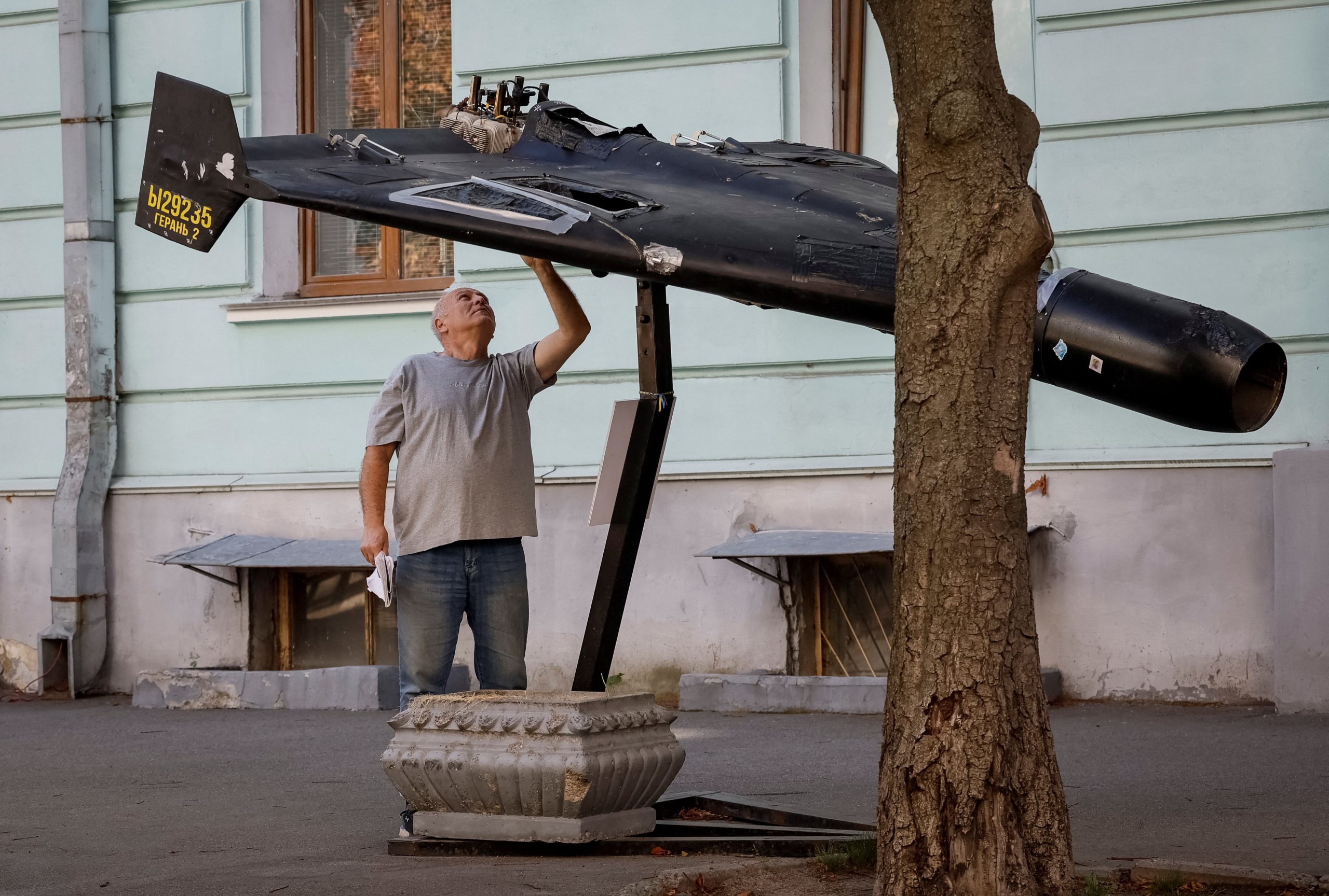 Homem observa drone russo derrubado em exposição nas ruas de Kiev