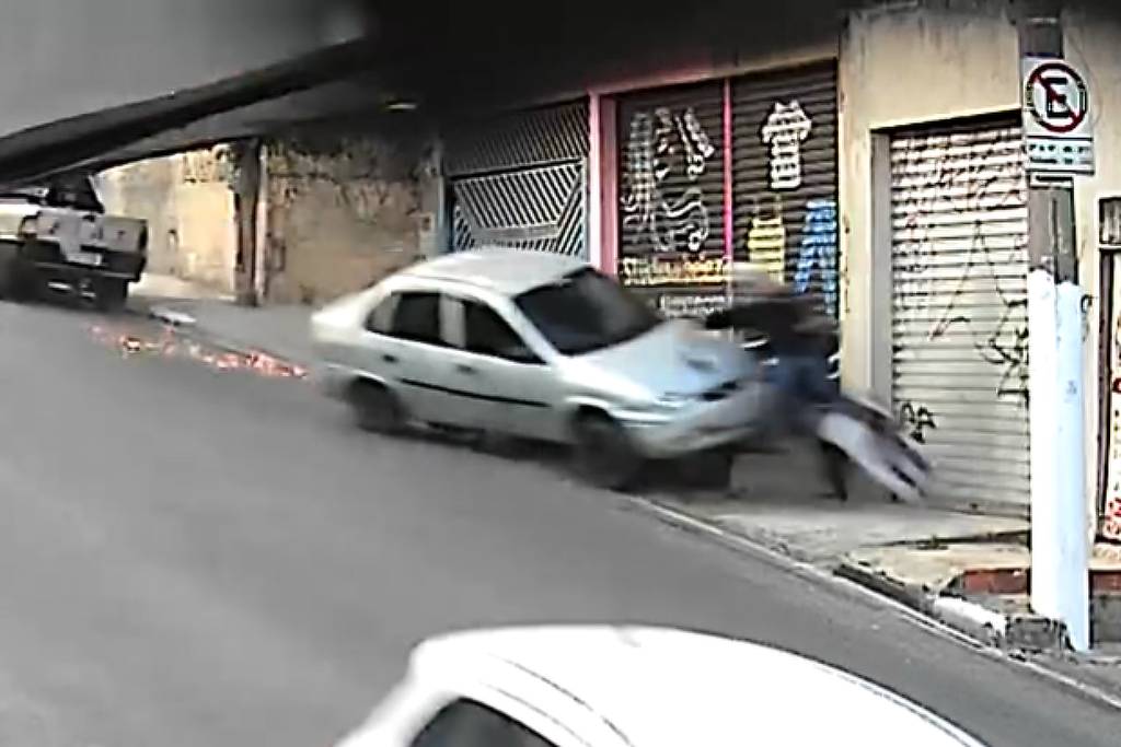 Carro branco ao lado de motocicleta em rua do Capão Redondo