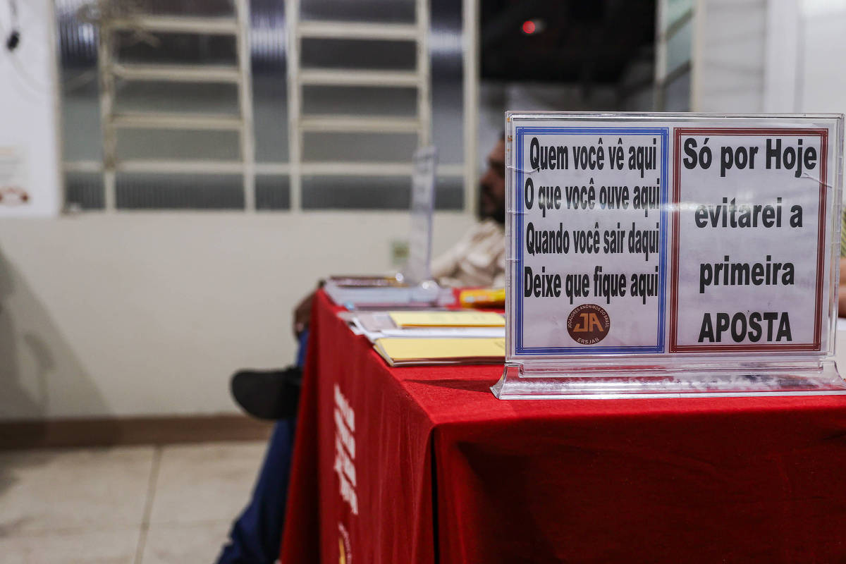 Mesa de grupo dos Jogadores Anônimos com avisos sobre apostas
