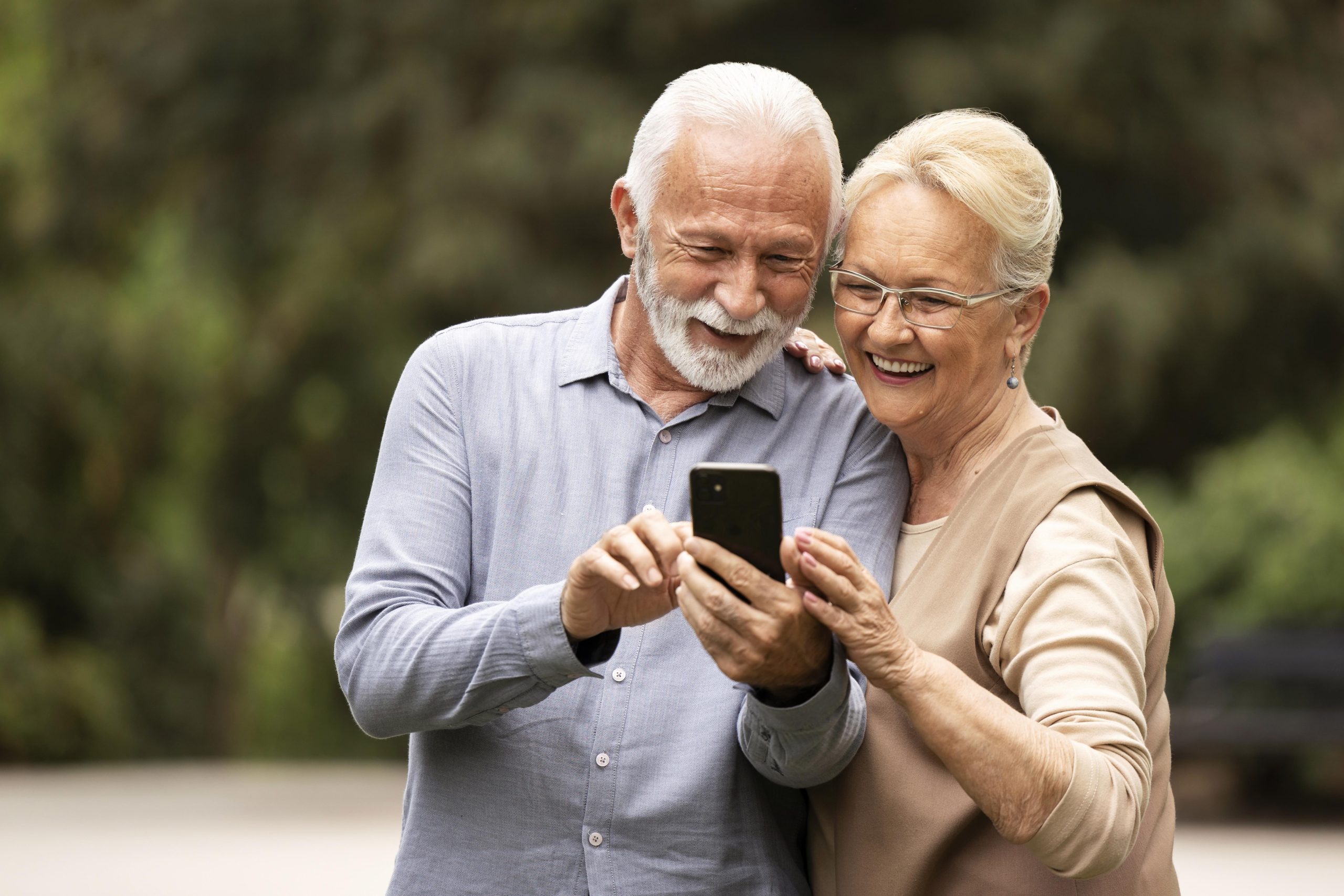 Idoso usando celular com as mãos