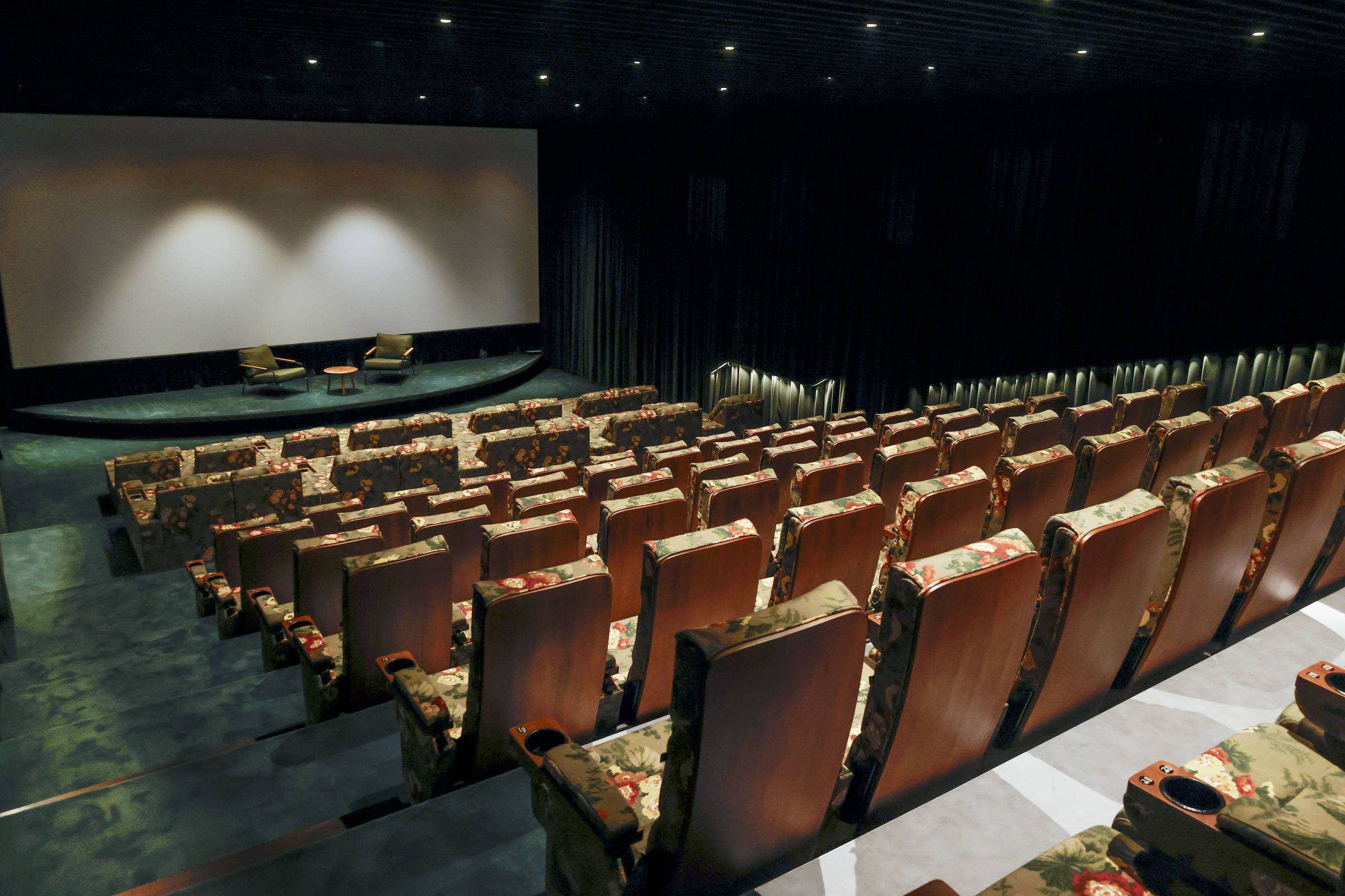 Sala de projeção do Cine Tutu com poltronas florais