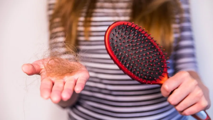 Escova de cabelo com fios presos entre as cerdas