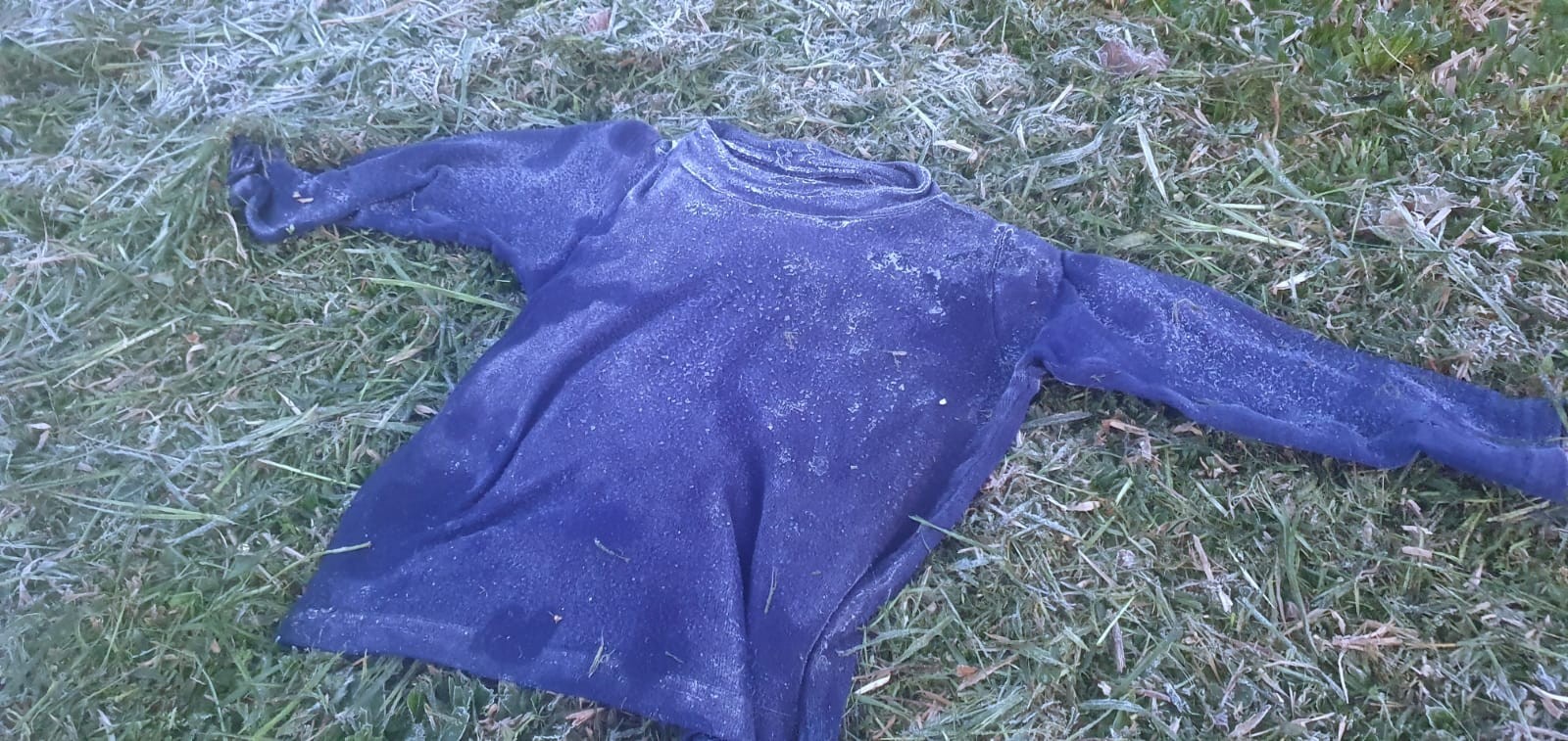 Peça de roupa congelada sobre a relva em dia de frio na Serra de Santa Catarina