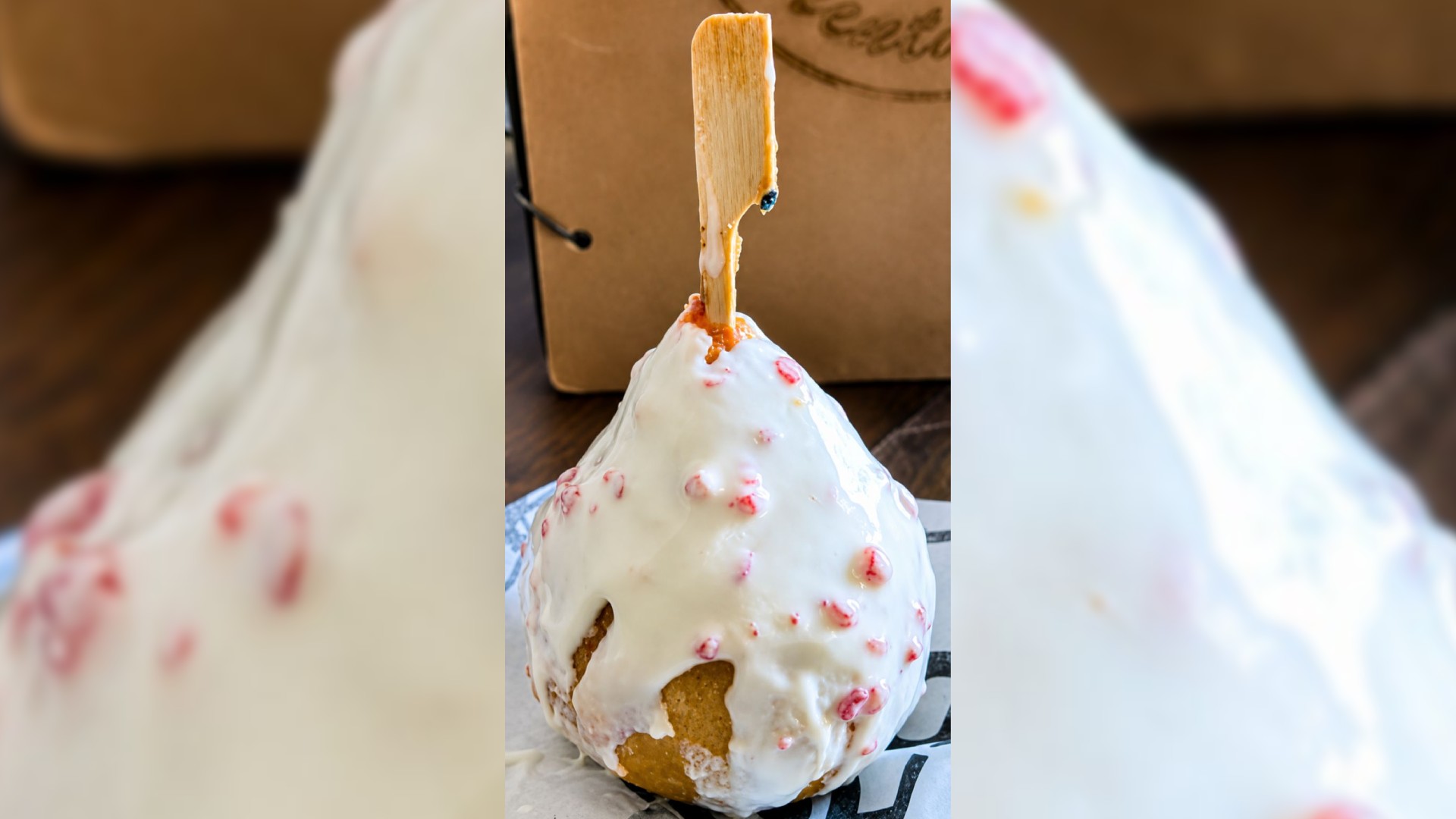 Coxinha de morango cravejado coberta com chocolate branco e caramelo vermelho