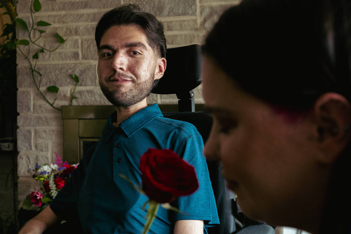 Andres Rodriguez em cadeira de rodas e Ellen Froliklong com uma rosa vermelha