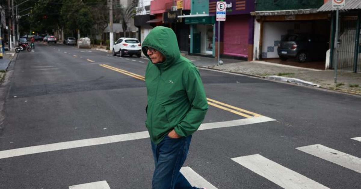 Pessoa caminha em dia frio na cidade de São Paulo