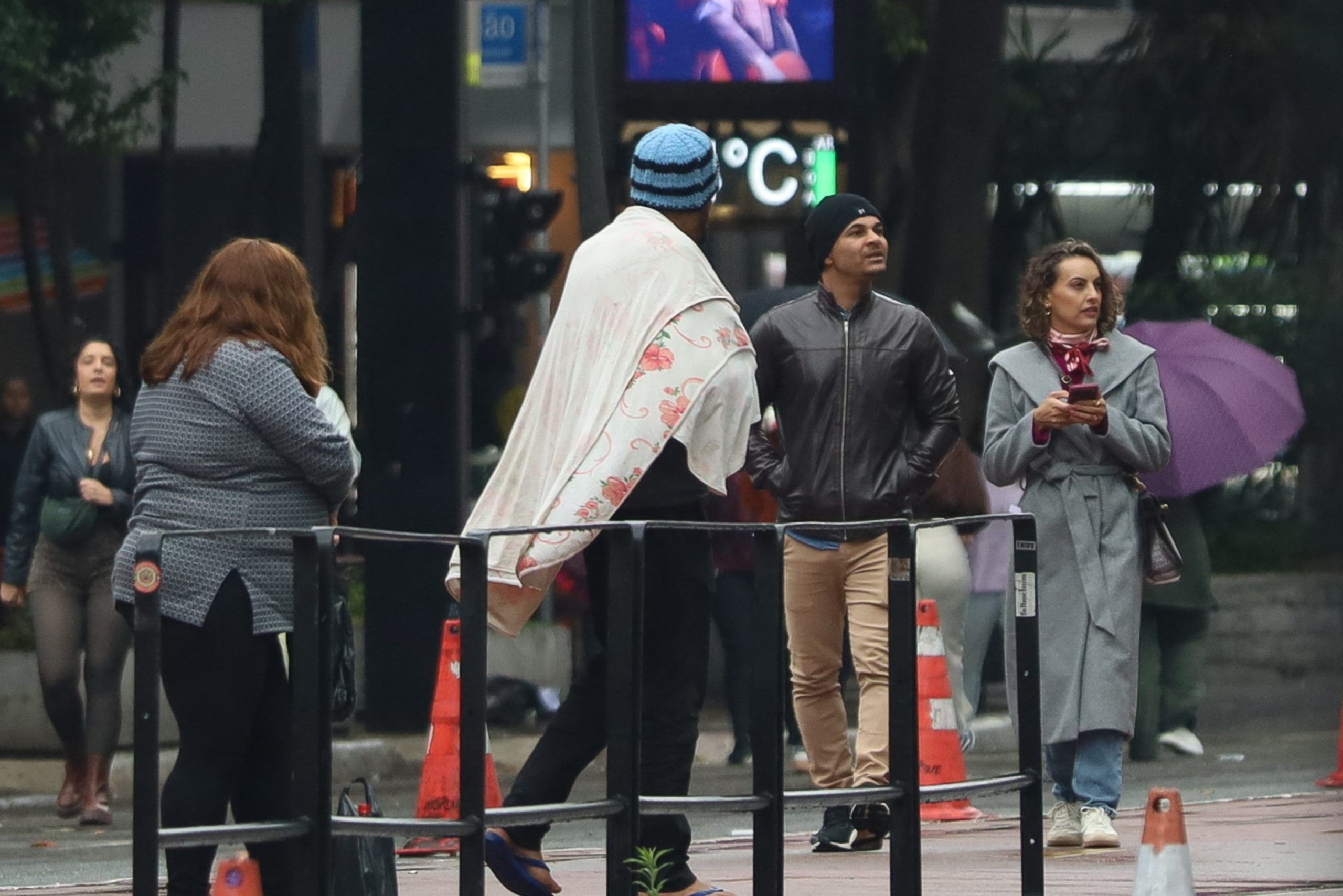 Pedestres caminham sob frio e garoa na Avenida Paulista, em São Paulo