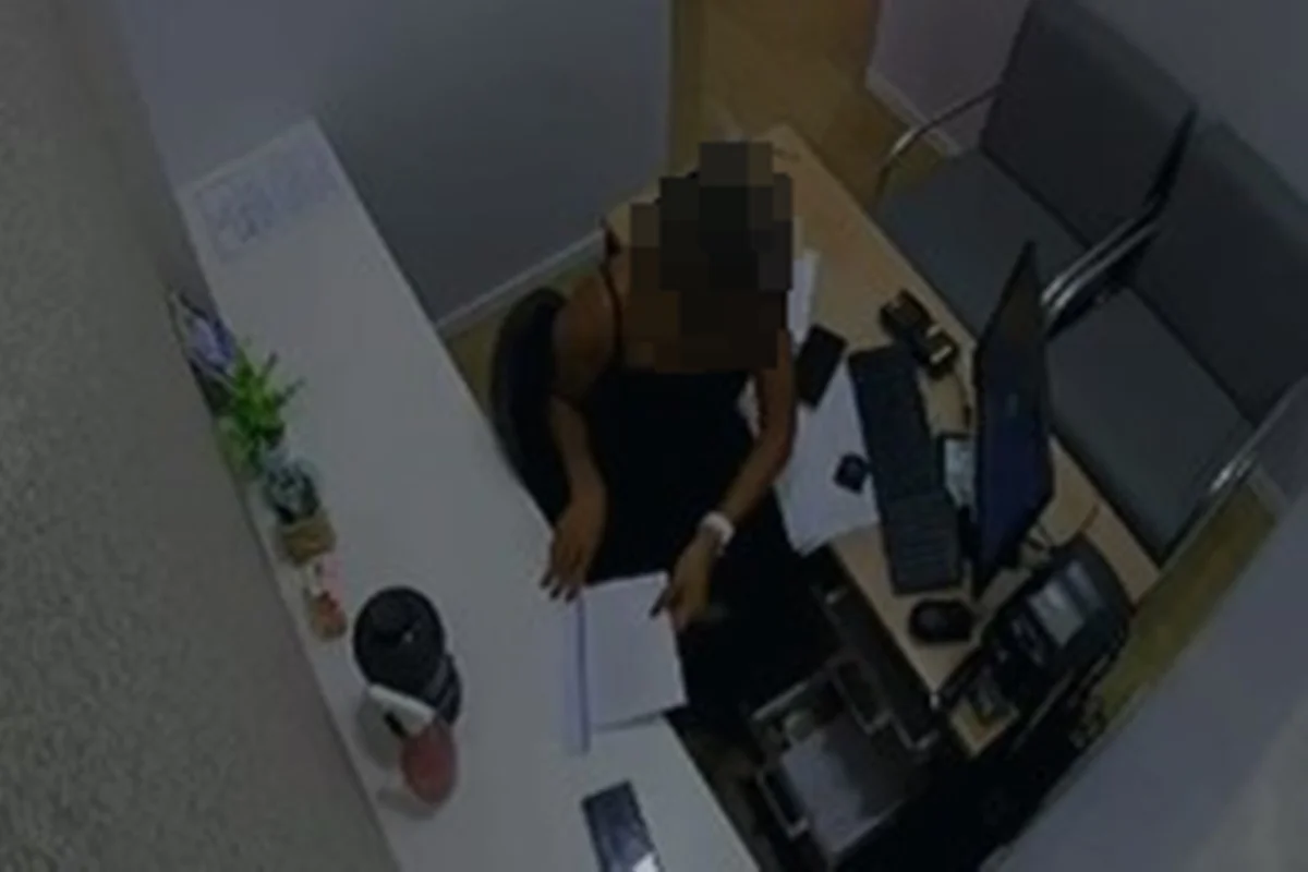 Funcionária ao lado de gaveta de caixa em clínica odontológica
